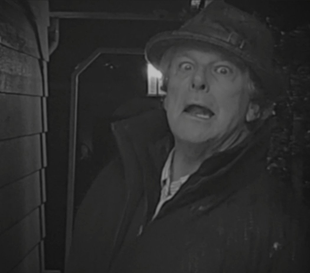 A creep fellow lingers in a doorway, an homage to film noir characters.