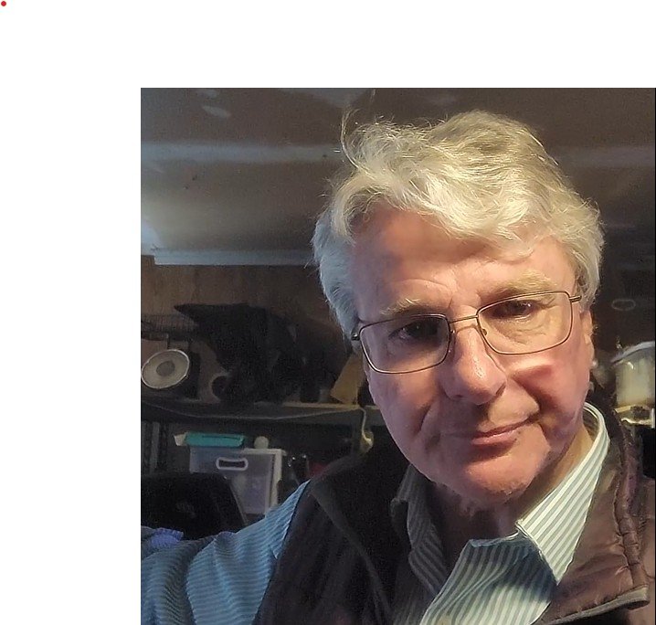 A closeup of writer, author and host John D Reinhart.