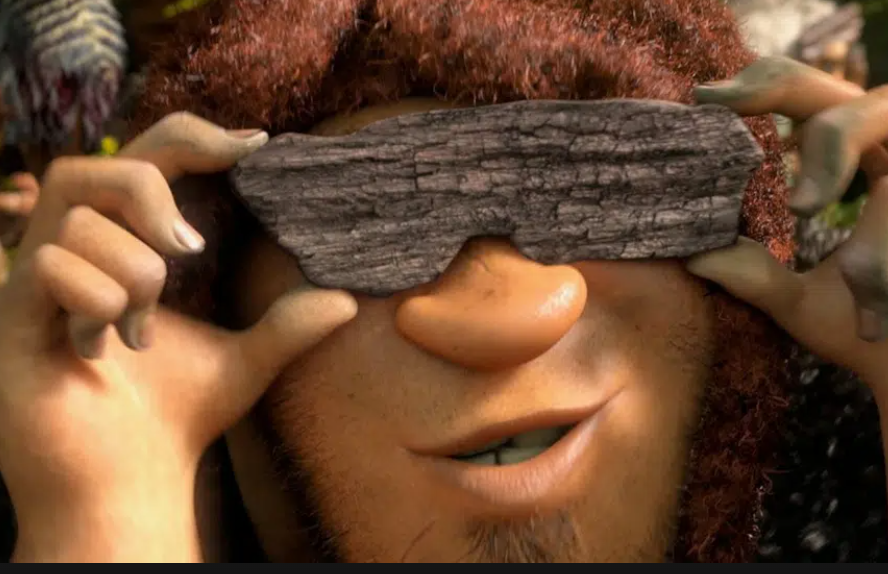 Dreamwork's Grug holds a rock over his eyes, imitating sunglasses.